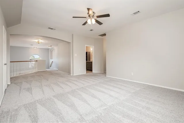 a view of a livingroom with a ceiling fan a kitchen space and a ceiling fan