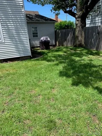 a view of a house with backyard and a tree