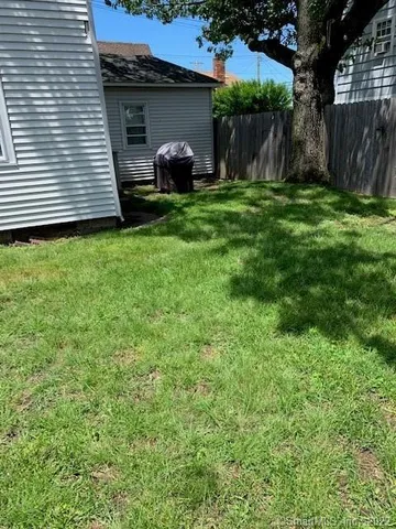 a view of a house with backyard and a tree