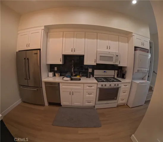 a kitchen with appliances a sink and cabinets
