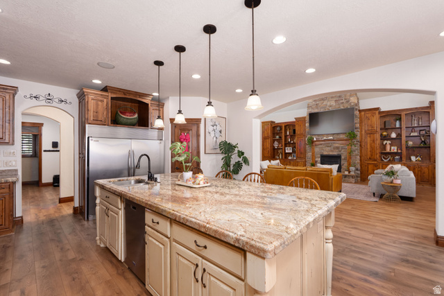 687 South 2080th Street East Springville, UT 84663 - Photo 6 of 149 Spacious kitchen island featuring a light-toned countertop, integrated sink with a gooseneck faucet, and pendant lighting overhead