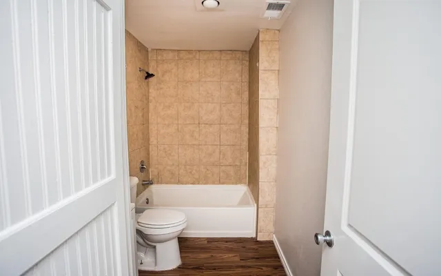 a bathroom with a toilet and a shower