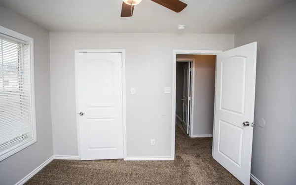 an empty room with windows and closet