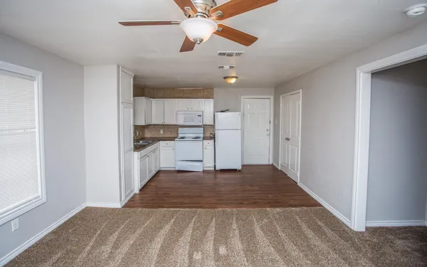 a view of a kitchen with wooden floor a sink and a window