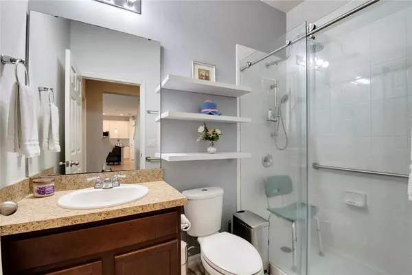 a bathroom with a granite countertop sink a toilet and shower