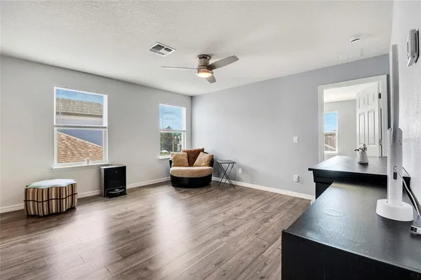 a living room with furniture and a wooden floor