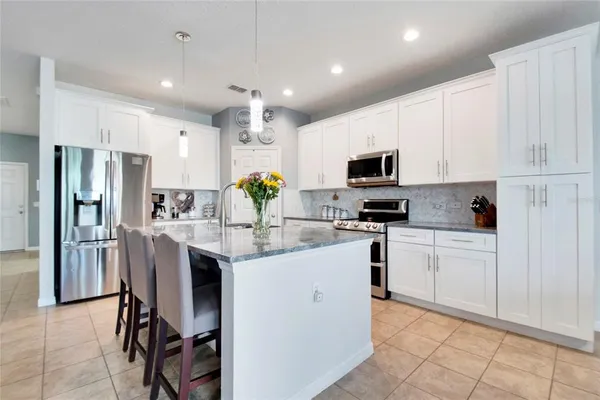 a kitchen with a sink stainless steel appliances and white cabinets