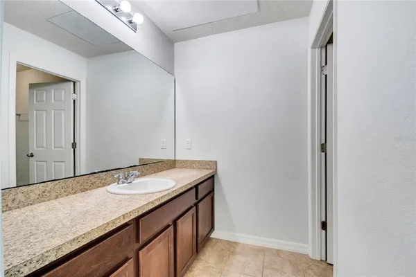 a bathroom with a granite countertop sink and a mirror