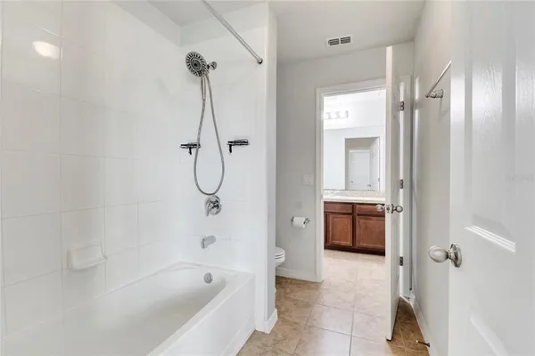 a bathroom with a tub shower and sink