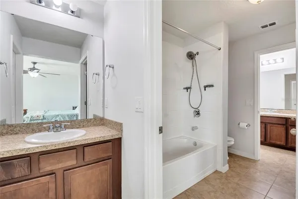 a bathroom with a tub sink shower and mirror