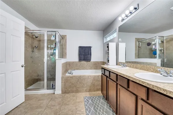 a spacious bathroom with a double vanity sink a mirror and a shower