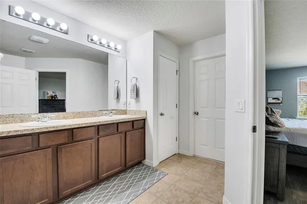 a spacious bathroom with a granite countertop sink a mirror and a shower