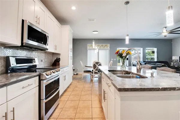 a kitchen with stainless steel appliances granite countertop a sink a stove top oven a counter space and cabinets
