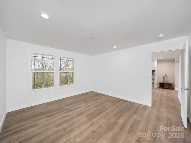 a view of a big room with wooden floor and a window