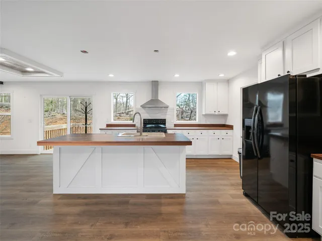 a kitchen with stainless steel appliances granite countertop a refrigerator a sink a stove and oven