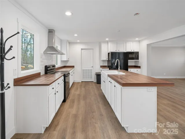a large kitchen with stainless steel appliances sink a microwave and cabinets