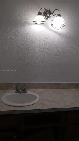 a bathroom with a sink and a light fixture