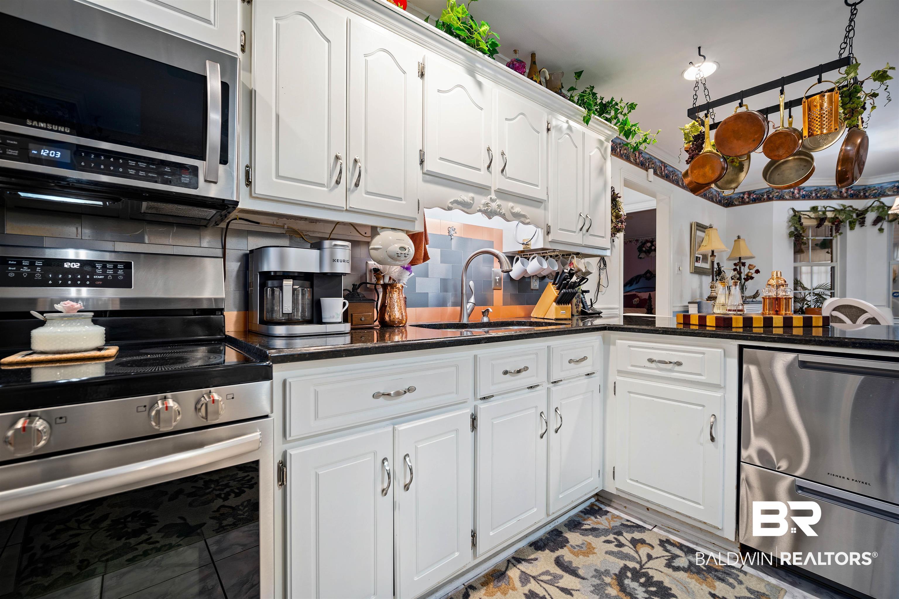 1744 Aden Road Mobile, AL 36695 - Photo 10 of 35 Kitchen with white cabinets, stainless steel appliances, tasteful backsplash, and sink