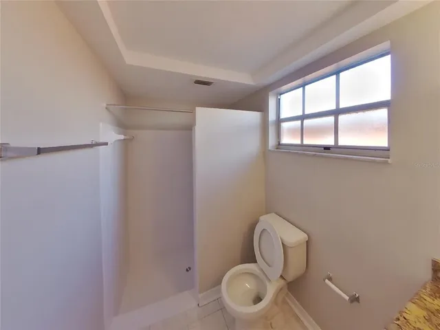 a bathroom with a toilet and a window