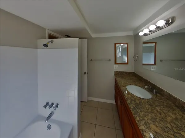 a bathroom with a granite countertop sink a toilet and shower