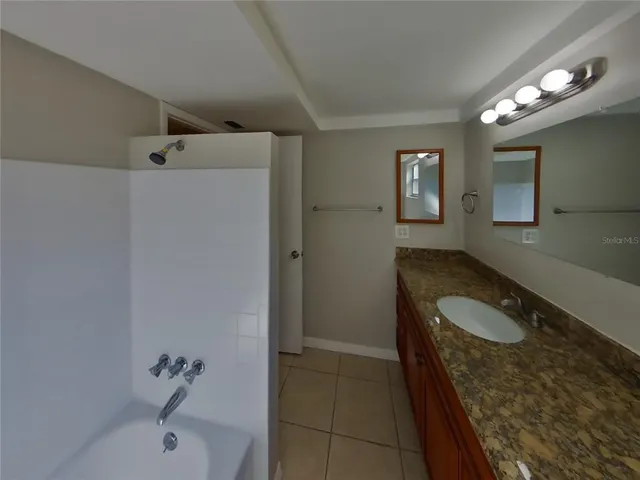 a bathroom with a granite countertop sink a toilet and shower