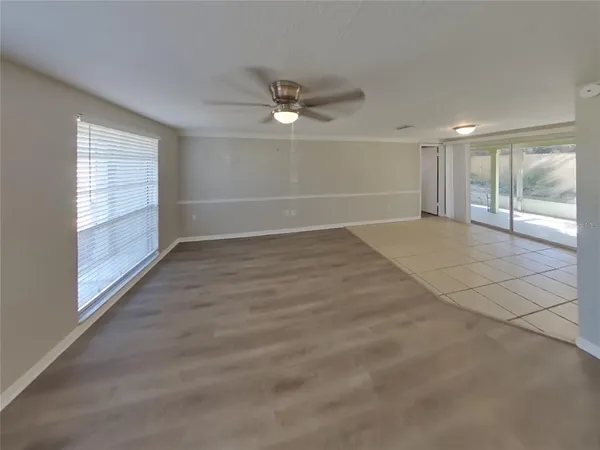 en empty room with windows and ceiling fan view