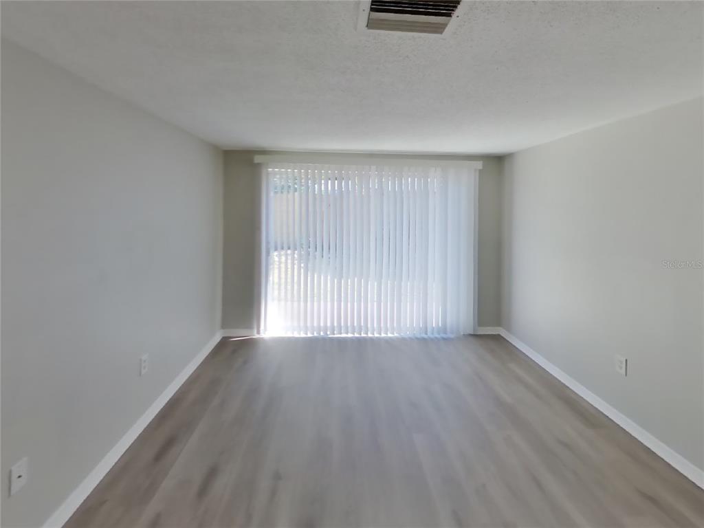 Undisclosed Address Holiday, FL 34691 - Photo 4 of 18 an empty room with wooden floor and windows