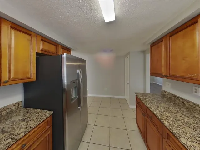 a kitchen with granite countertop a refrigerator and a sink
