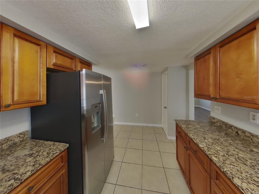 Undisclosed Address Holiday, FL 34691 - Photo 7 of 18 a kitchen with granite countertop a refrigerator and a sink