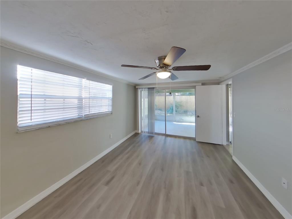 Undisclosed Address Holiday, FL 34691 - Photo 9 of 18 a view of an empty room with wooden floor and a window