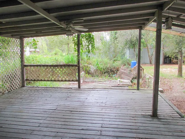 a view of empty room with wooden floor and floor to ceiling window