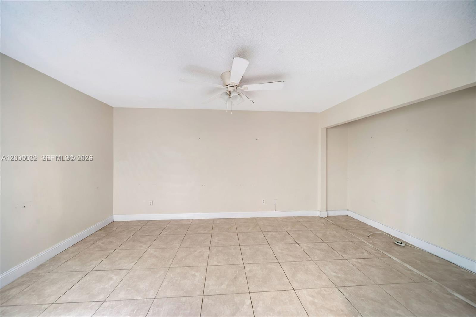5223 Gate Lake Road, Unit 5223 Tamarac, FL 33319 - Photo 7 of 37 an empty room with a ceiling fan and carpet