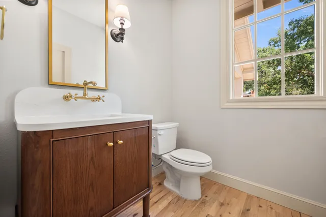 a bathroom with a sink vanity mirror and toilet