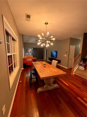 a dining room with wooden floor and chandelier