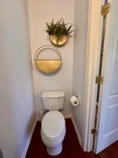 a bathroom with a toilet and a mirror