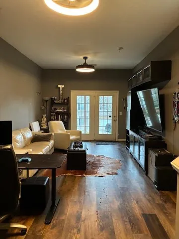 a living room with furniture a window and a flat screen tv
