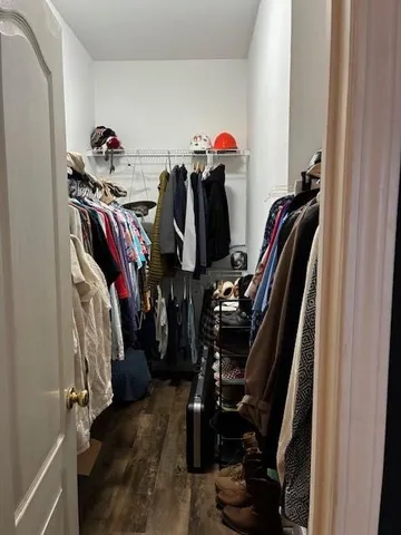 a view of walk in closet with clothes and shoes