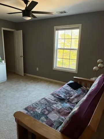 a bed sitting in a bedroom next to a window