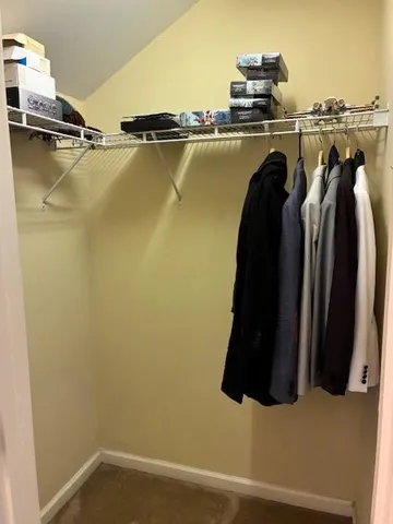 a view of walk in closet with clothes and shoes