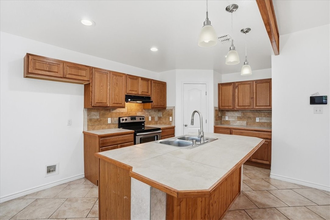 107 South 4th Street Odem, TX 78370 - Photo 11 of 29 a kitchen with granite countertop a stove refrigerator and microwave