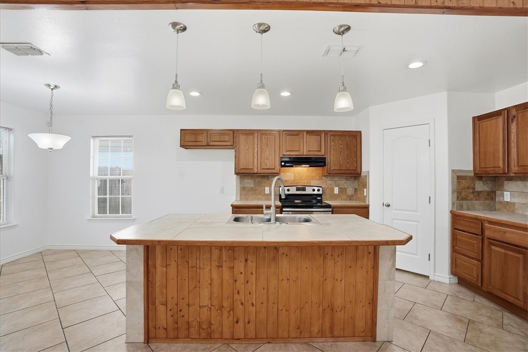 107 South 4th Street Odem, TX 78370 - Photo 12 of 29 a kitchen with stainless steel appliances a sink a stove top oven a counter space and cabinets
