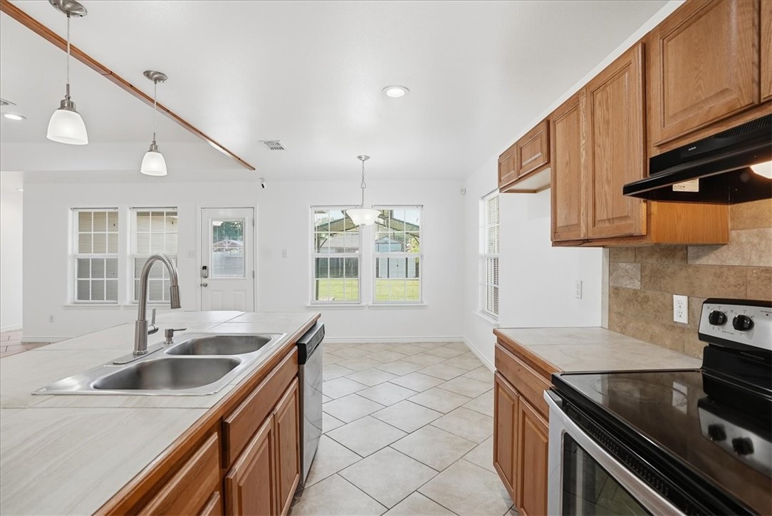 107 South 4th Street Odem, TX 78370 - Photo 13 of 29 a kitchen with stainless steel appliances a sink a stove and cabinets