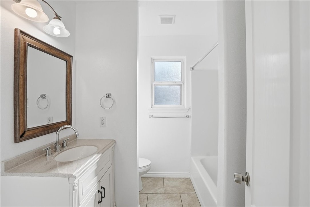 107 South 4th Street Odem, TX 78370 - Photo 22 of 29 a bathroom with a granite countertop sink toilet and shower
