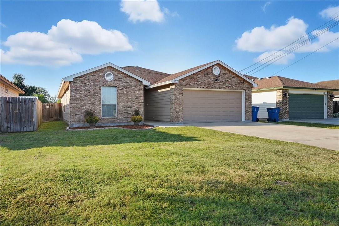 107 South 4th Street Odem, TX 78370 - Photo 3 of 29 a front view of a house with a yard and garage