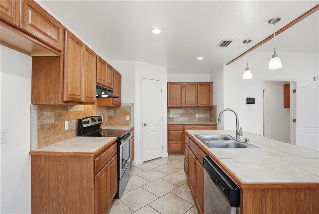 107 South 4th Street Odem, TX 78370 - Photo 10 of 29 a kitchen with stainless steel appliances granite countertop a sink stove and refrigerator