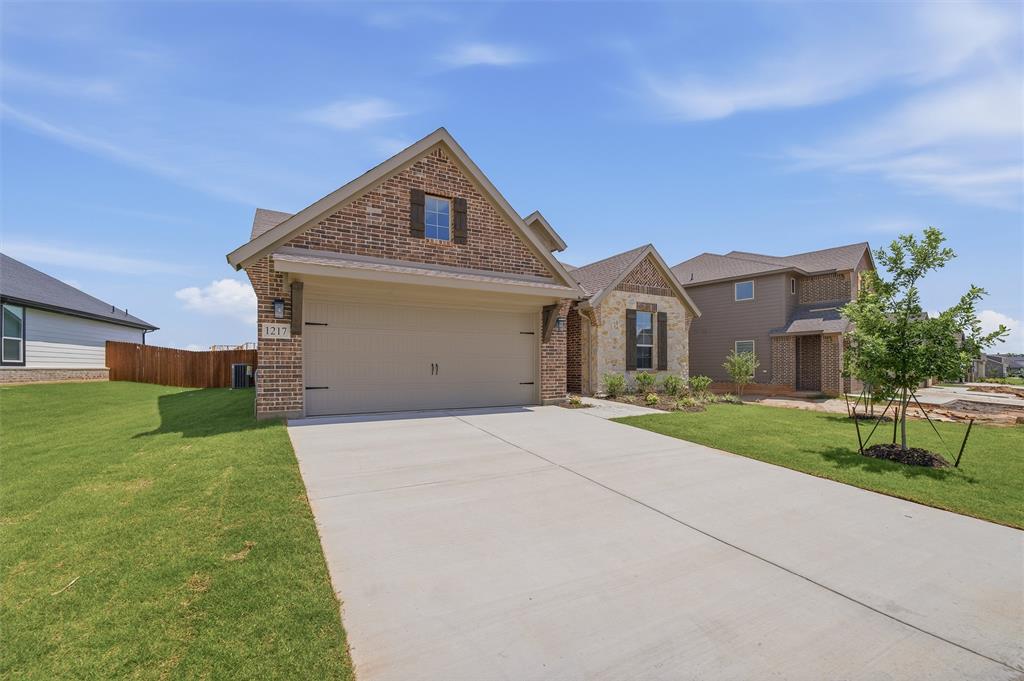 1217 Colca Drive Springtown, TX 76082 - Photo 3 of 25 Brick and stone façade with an attached garage, concrete driveway, and front landscaping