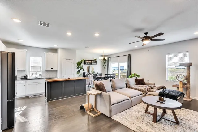 a living room with kitchen island furniture and a chandelier