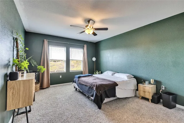 a spacious bedroom with a bed and a chandelier