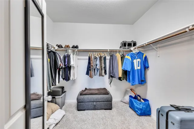 a view of walk in closet with clothes and shoes