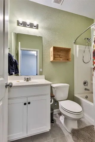 a bathroom with a toilet a sink a mirror and vanity